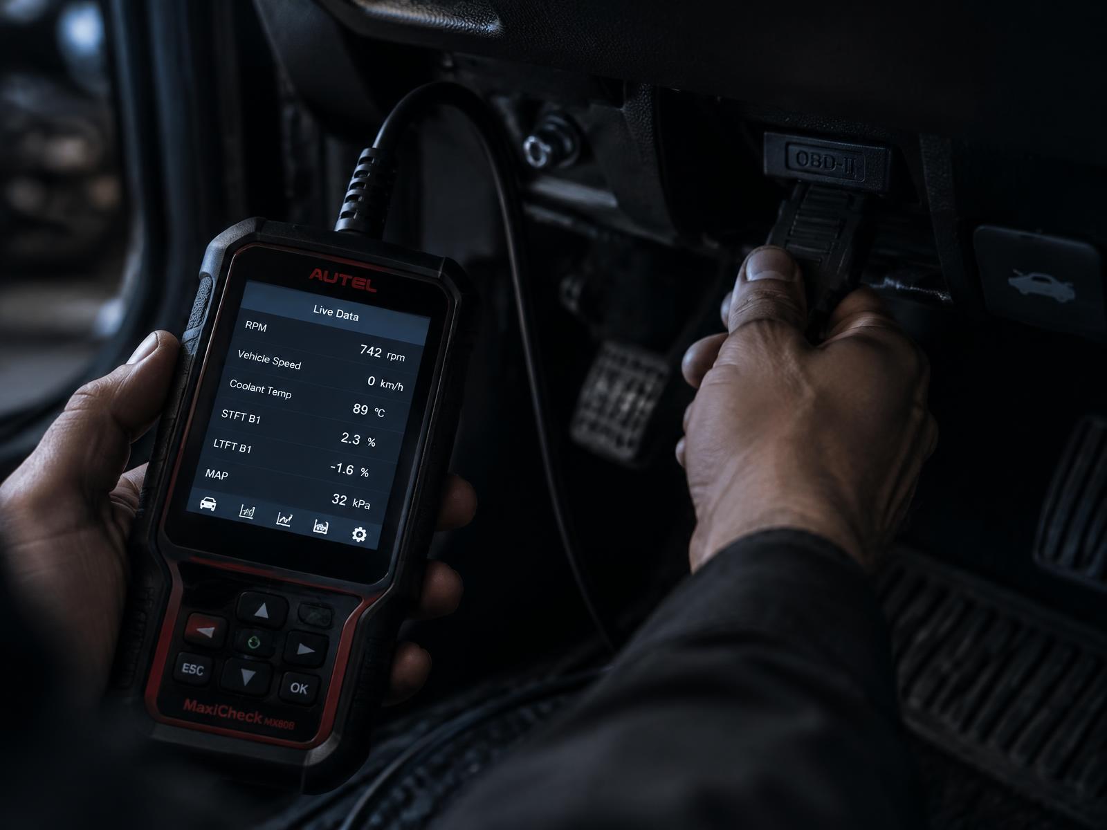 Mecânico conectando um scanner automotivo na porta OBD do carro
